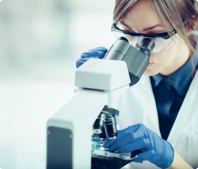 Scientist looking through a microscope.